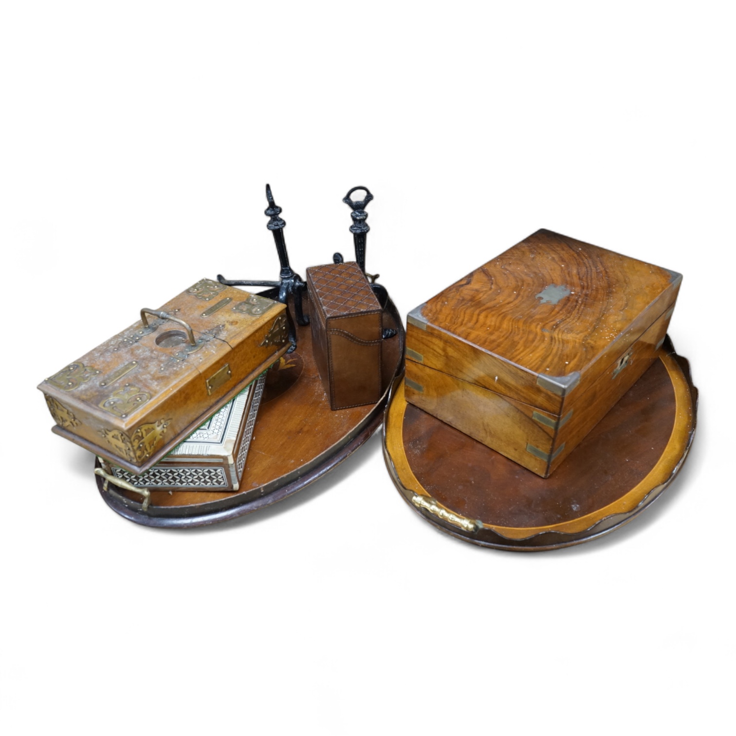 Two mahogany oval inlaid trays, brass bound cigarette box and writing box, a pair of fire dogs, a leather box and mother of pearl inlaid box. (8). Shell inlay tray 59cm wide. Condition - tray edge has minor damage.